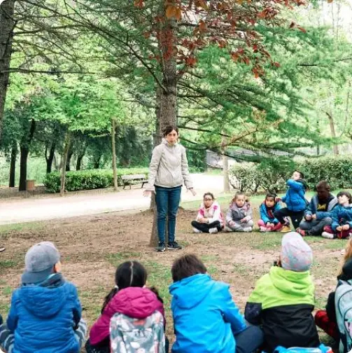 Docente realizando una actividad de educación ambiental con alumnado al aire lib